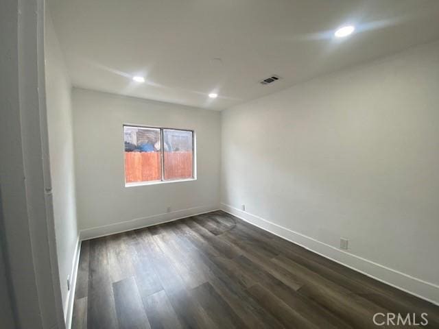 spare room featuring recessed lighting, baseboards, visible vents, and dark wood-style floors