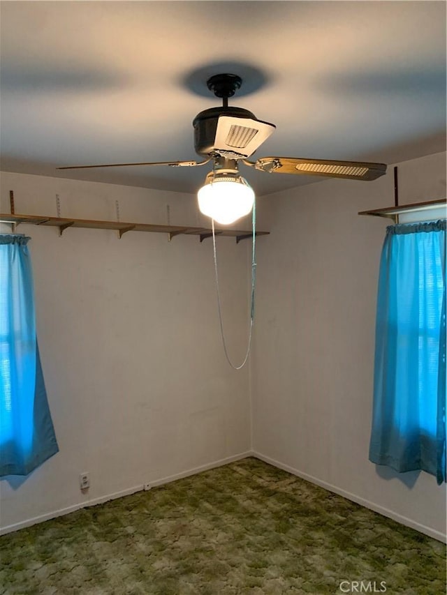 spare room with baseboards and a ceiling fan