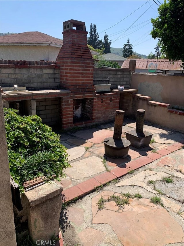 view of patio / terrace featuring an outdoor brick fireplace