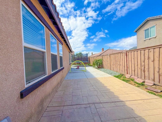 view of patio / terrace with a fenced backyard and a trampoline