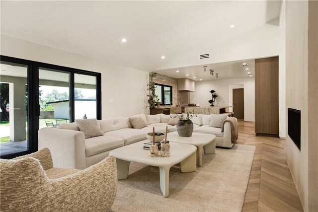 living room featuring high vaulted ceiling, recessed lighting, and visible vents