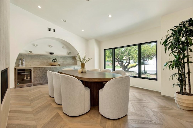 dining room with visible vents, recessed lighting, wine cooler, and vaulted ceiling