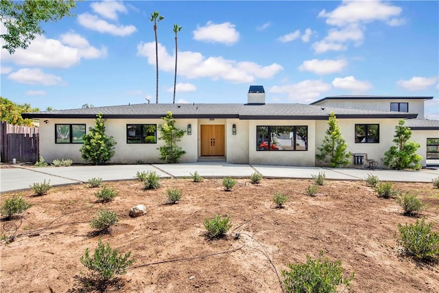 ranch-style home featuring fence and stucco siding