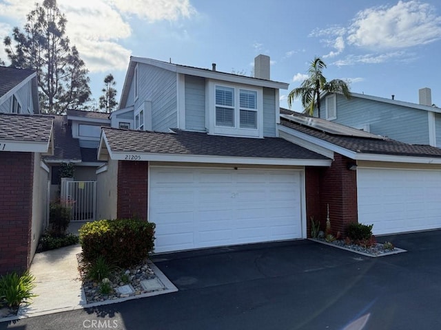 21205 Serra Unit 42, Lake Forest, CA 92630 - townhome / multi-family property featuring aphalt driveway, brick siding, and a chimney