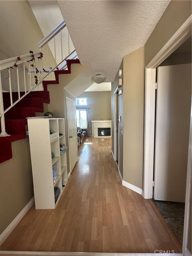 21205 Serra Unit 42, Lake Forest, CA 92630 - hall featuring baseboards, stairway, and wood finished floors