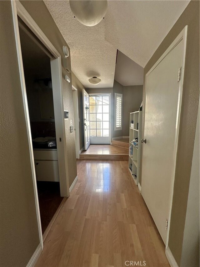 21205 Serra Unit 42, Lake Forest, CA 92630 - hall with light wood-style floors, baseboards, and a textured ceiling