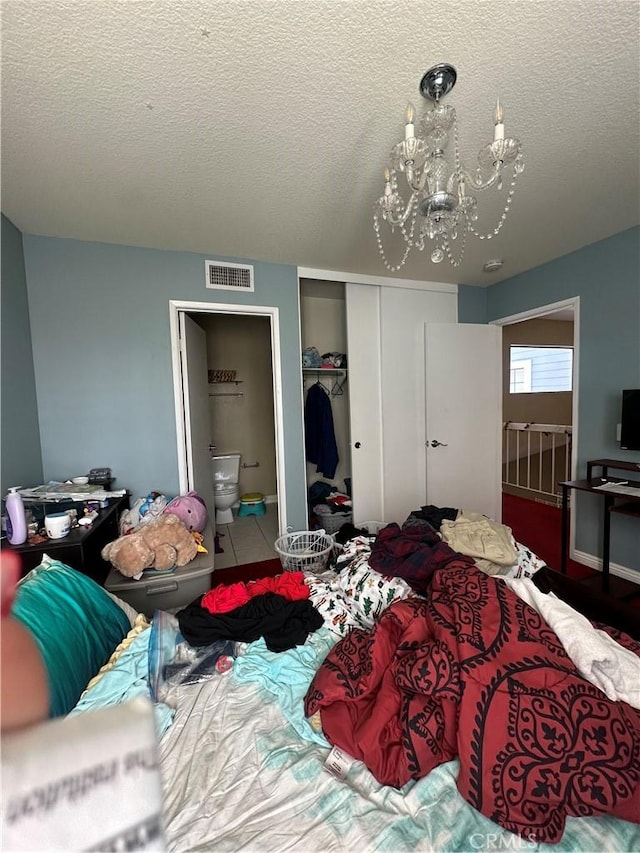 21205 Serra Unit 42, Lake Forest, CA 92630 - bedroom featuring a closet, a textured ceiling, visible vents, a chandelier, and connected bathroom