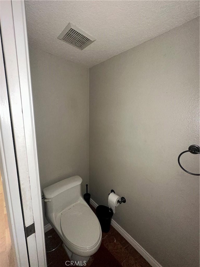 21205 Serra Unit 42, Lake Forest, CA 92630 - bathroom featuring toilet, visible vents, baseboards, and a textured ceiling