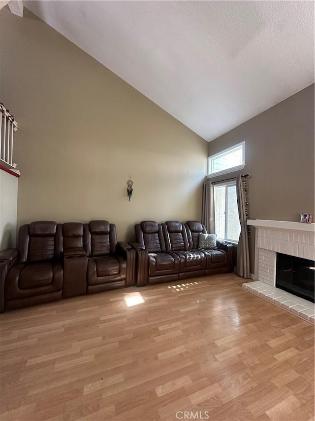 21205 Serra Unit 42, Lake Forest, CA 92630 - living area with light wood-style floors, high vaulted ceiling, and a brick fireplace