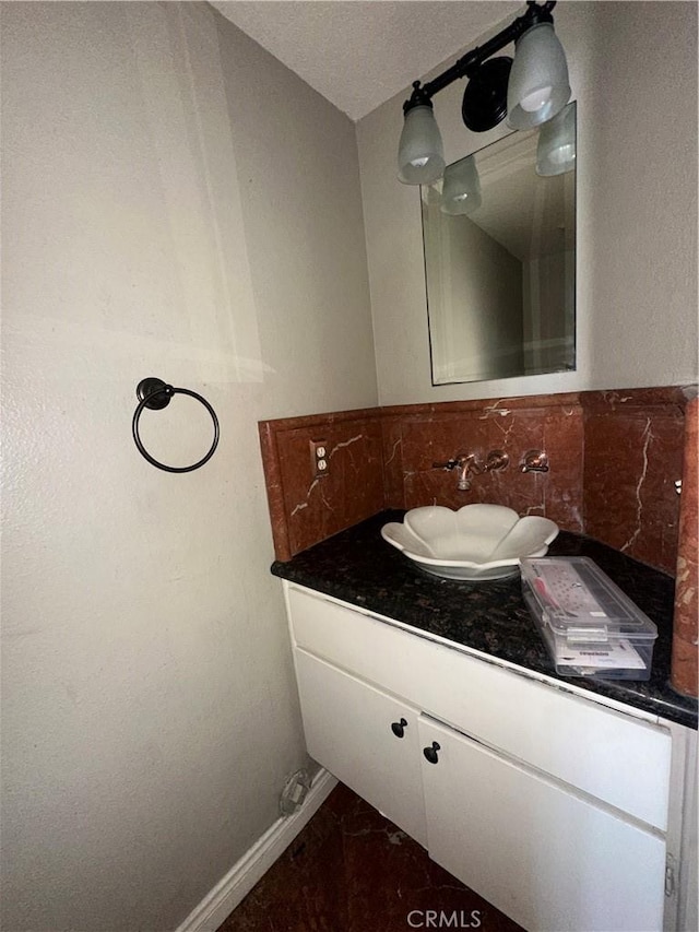 21205 Serra Unit 42, Lake Forest, CA 92630 - bathroom featuring vanity, decorative backsplash, baseboards, and marble finish floor