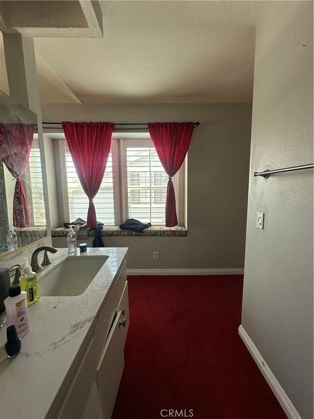 21205 Serra Unit 42, Lake Forest, CA 92630 - bathroom with a textured ceiling, baseboards, and vanity
