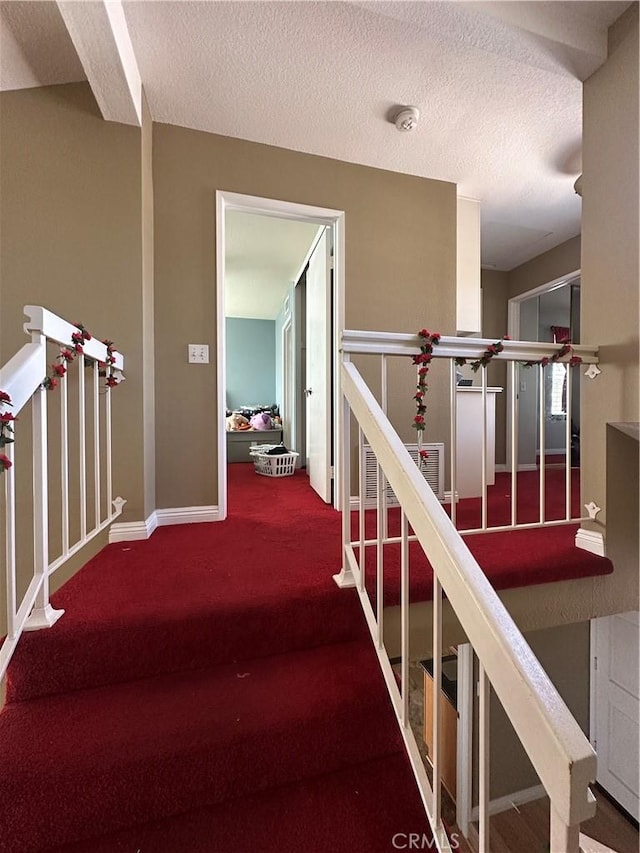 21205 Serra Unit 42, Lake Forest, CA 92630 - stairway featuring a textured ceiling, baseboards, and carpet floors