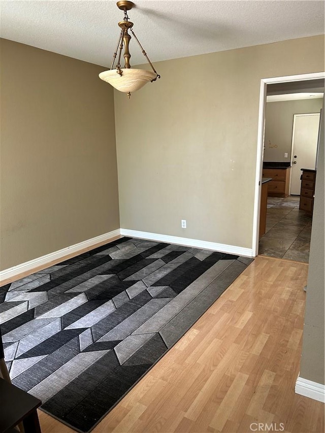 21205 Serra Unit 42, Lake Forest, CA 92630 - unfurnished room featuring wood finished floors and a textured ceiling