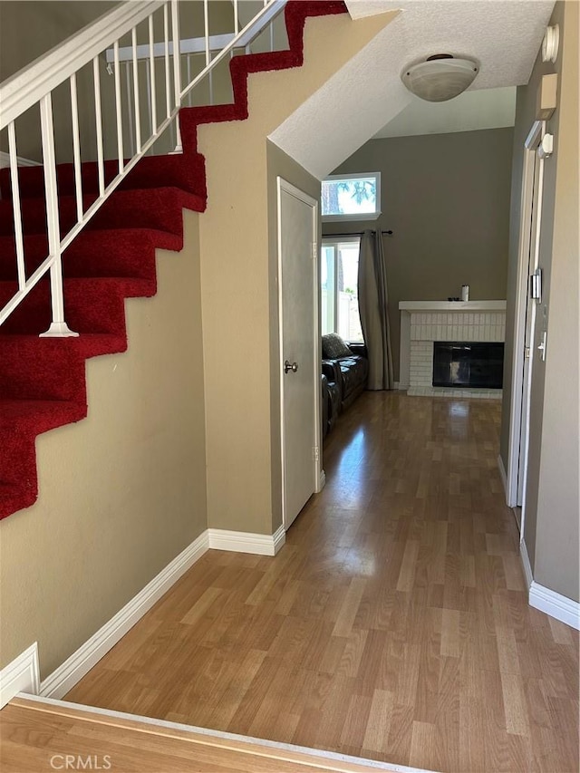 21205 Serra Unit 42, Lake Forest, CA 92630 - stairway with wood finished floors and a fireplace