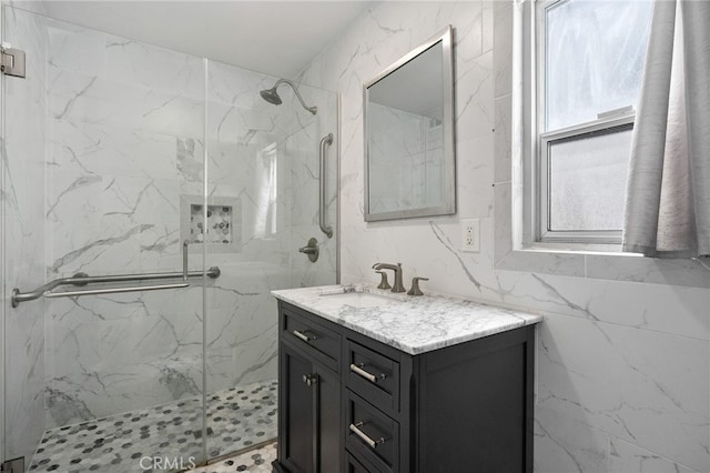 full bathroom with a marble finish shower and vanity