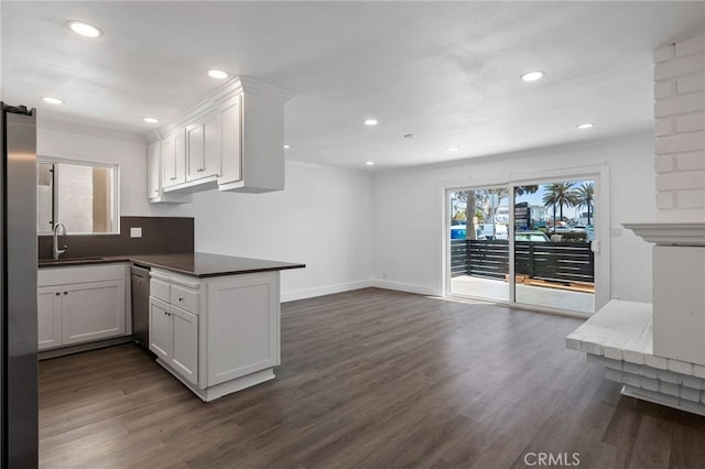 kitchen with ornamental molding, dark wood-style flooring, white cabinets, and stainless steel appliances