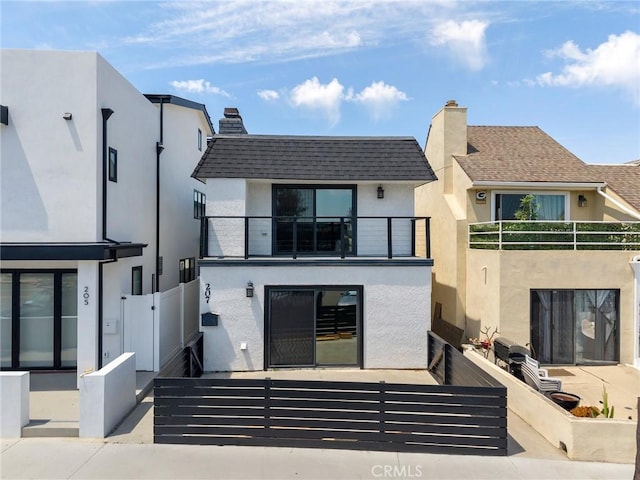 207 28th St, Newport Beach, CA 92663 - rear view of house featuring a balcony, stucco siding, a gate, and a chimney