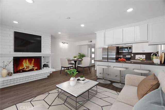 207 28th St, Newport Beach, CA 92663 - living room with light wood-style floors, recessed lighting, a brick fireplace, and baseboards