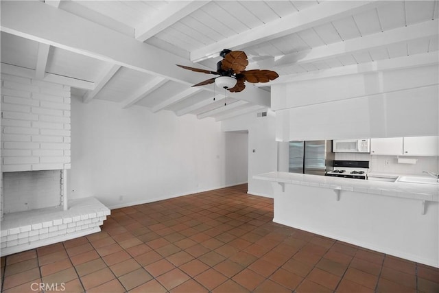207 28th St, Newport Beach, CA 92663 - unfurnished living room with beamed ceiling, a ceiling fan, a sink, a fireplace, and dark tile patterned floors