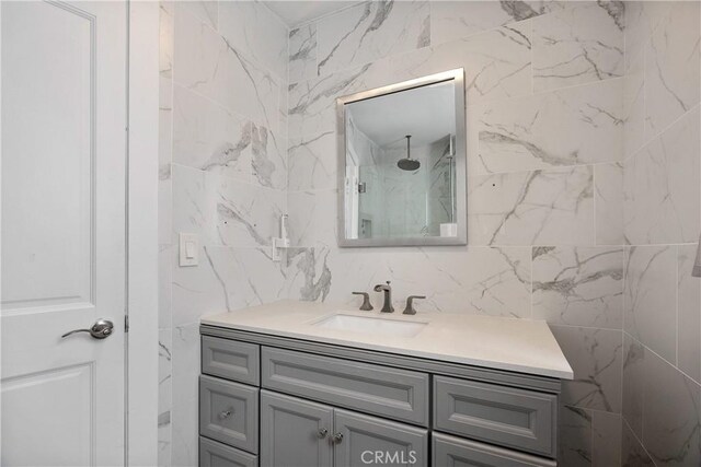 207 28th St, Newport Beach, CA 92663 - bathroom featuring tile walls, vanity, and a marble finish shower
