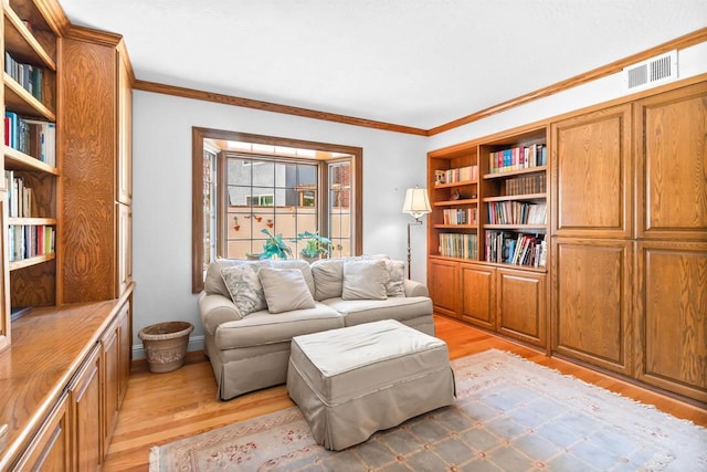 sitting room featuring crown molding, light wood finished floors, and visible vents