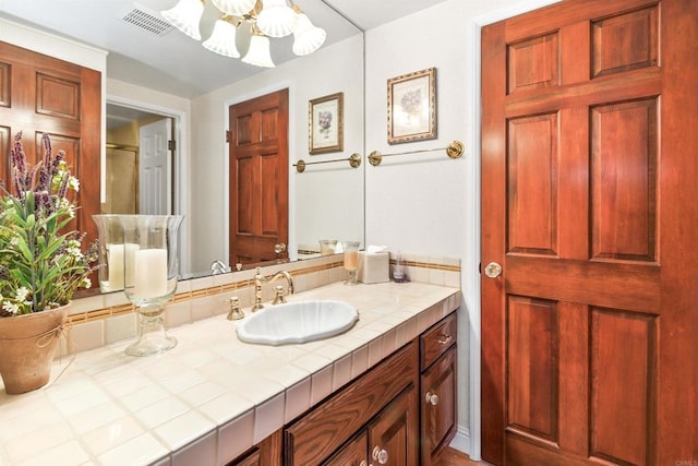 bathroom with a notable chandelier, visible vents, and vanity