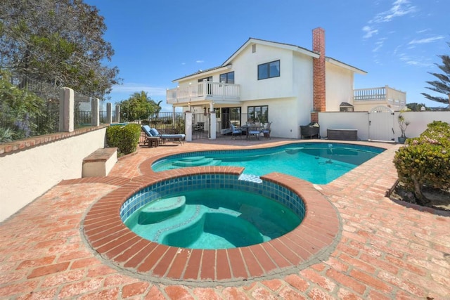 view of pool featuring a pool with connected hot tub, a gate, a fenced backyard, and a patio area