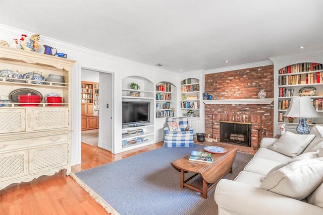 living room with visible vents, crown molding, built in features, a brick fireplace, and wood finished floors