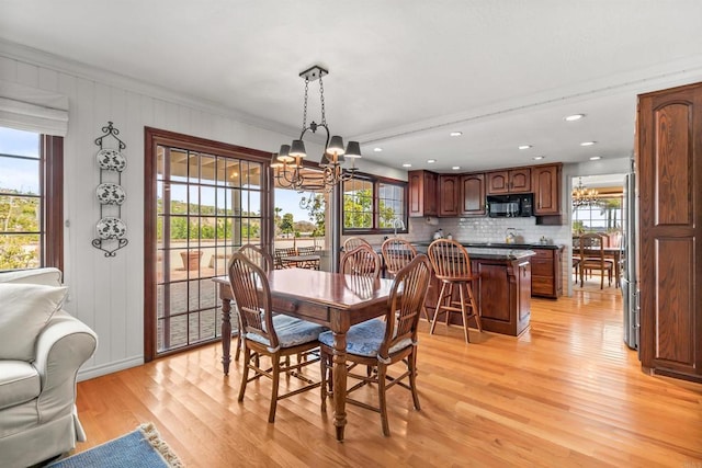 dining room featuring light wood-style flooring, a chandelier, and a wealth of natural light