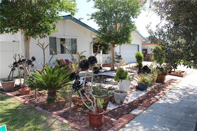 view of front of property with a garage, stucco siding, and fence