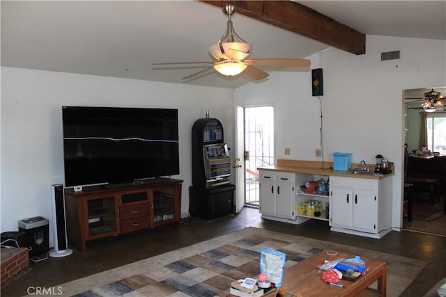 living area with ceiling fan, visible vents, and vaulted ceiling with beams