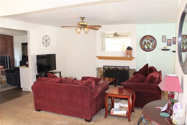 living room with carpet flooring, ceiling fan, and a fireplace