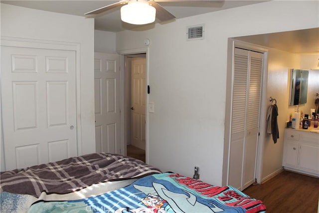 bedroom featuring ceiling fan, visible vents, wood finished floors, and a closet