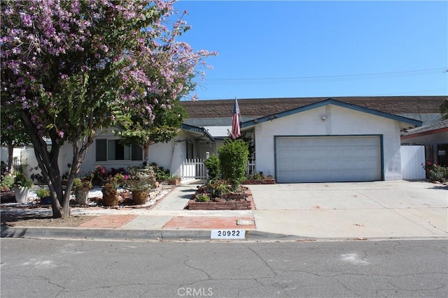 ranch-style house with stucco siding, driveway, and a garage