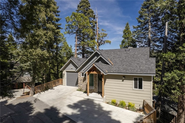 388 Primrose Cir, Lake Arrowhead, CA 92352 - craftsman-style home with fence, stone siding, a shingled roof, concrete driveway, and an attached garage