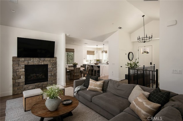 388 Primrose Cir, Lake Arrowhead, CA 92352 - living area featuring a notable chandelier, a stone fireplace, baseboards, wood finished floors, and visible vents