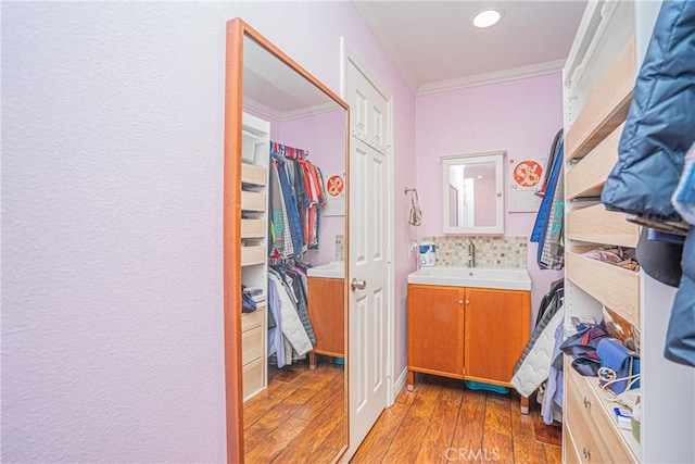 bathroom with decorative backsplash, vanity, ornamental molding, recessed lighting, and hardwood / wood-style floors