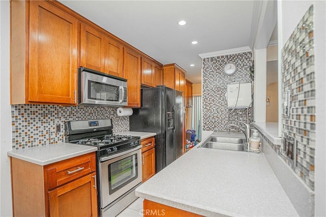 kitchen featuring crown molding, tasteful backsplash, a sink, light countertops, and stainless steel appliances