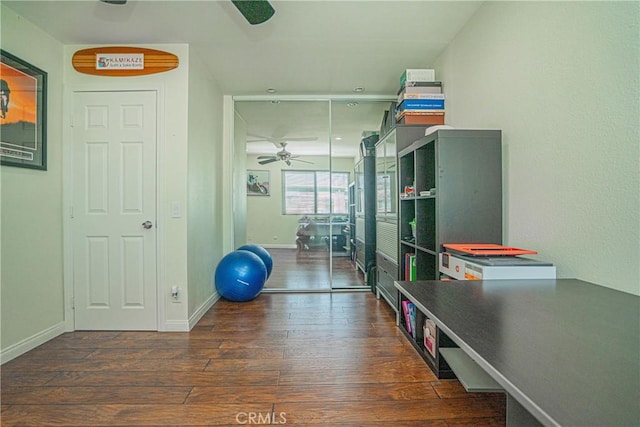 workout area with baseboards, a ceiling fan, and wood finished floors