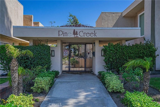 entrance to property featuring a gate and stucco siding
