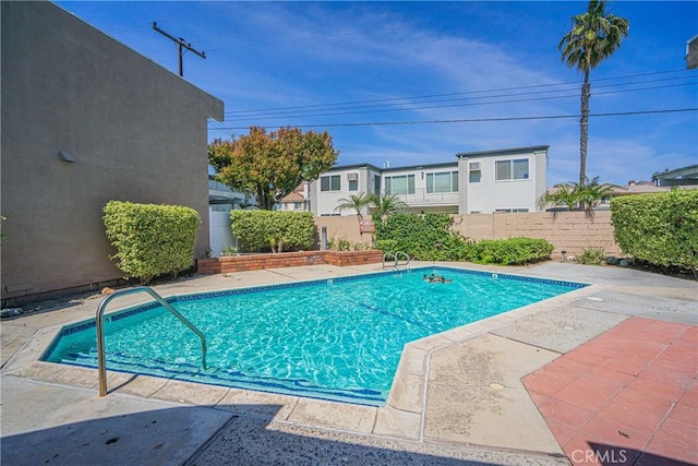 view of swimming pool featuring a fenced in pool, a fenced backyard, and a patio area