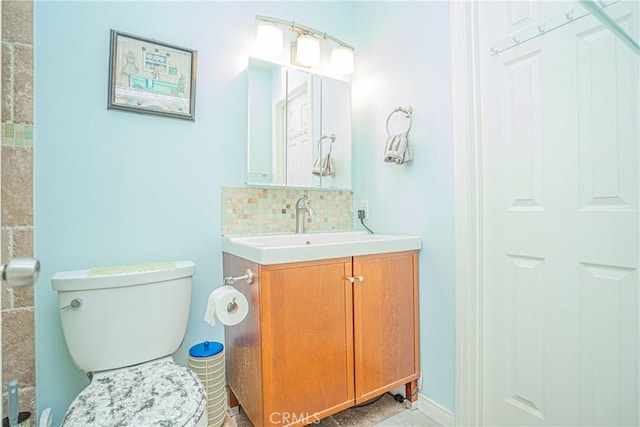 bathroom featuring vanity, toilet, and tasteful backsplash