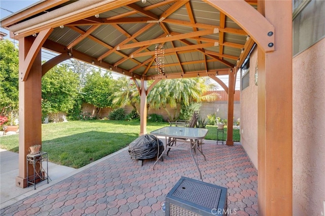 view of patio with fence, outdoor dining area, and a gazebo
