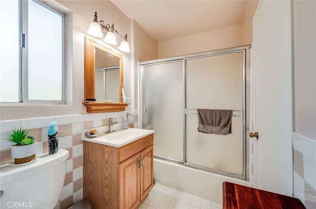 full bathroom with toilet, enclosed tub / shower combo, and vanity