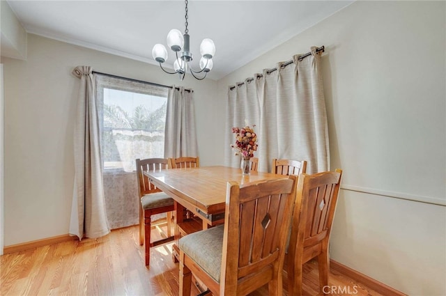 dining space with an inviting chandelier, baseboards, and light wood-type flooring