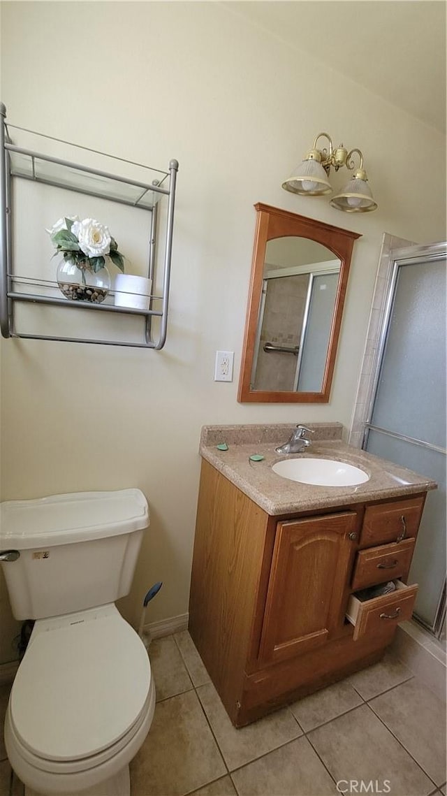 bathroom with tile patterned flooring, vanity, toilet, baseboards, and a shower stall