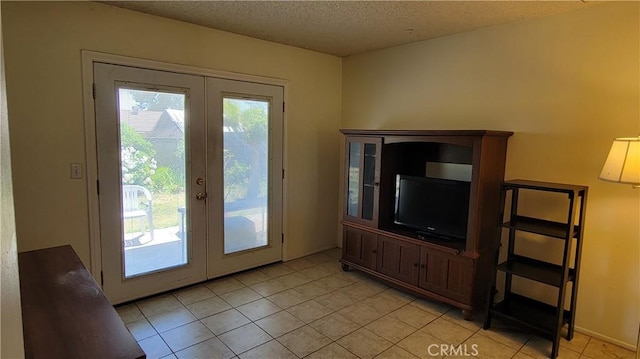 doorway with french doors, a textured ceiling, and light tile patterned flooring