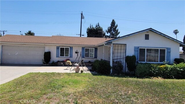 ranch-style home featuring stucco siding, driveway, a front yard, and a garage