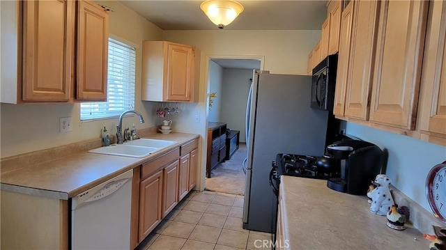 kitchen featuring light countertops, black microwave, a sink, and dishwasher