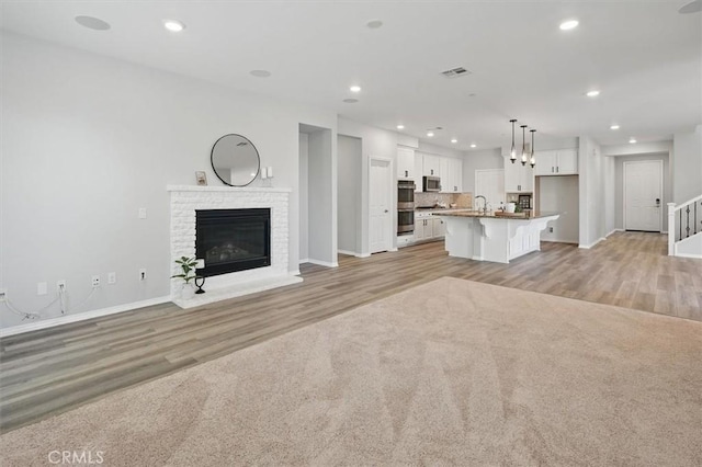 unfurnished living room featuring recessed lighting, baseboards, visible vents, and light wood-style floors